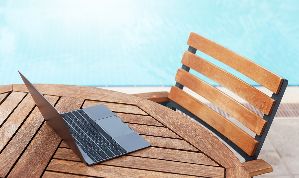 laptop on table near swimming pool XB8AL4K 2